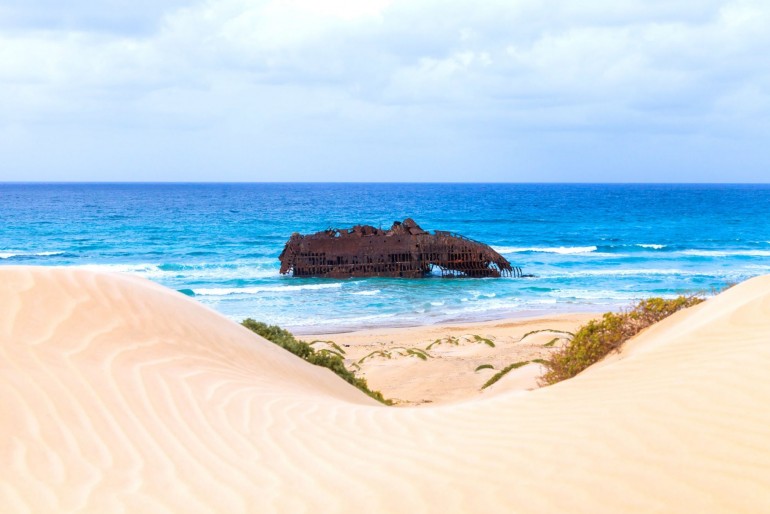 Písečné duny a vrak lodi v moři na ostrově Boa Vista